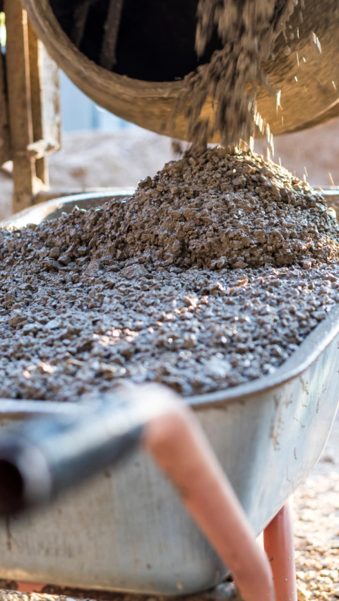 a machine pouring concrete on a wheelbarrow